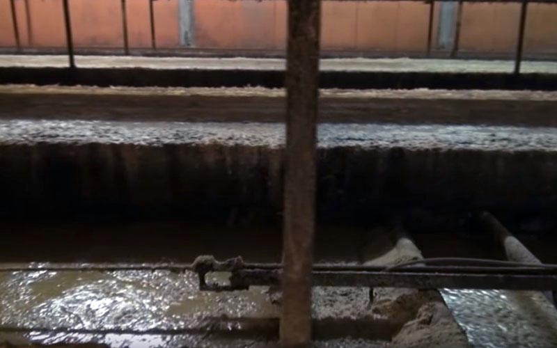Close-up view of the metal structures and waste on the floor beneath the cages.