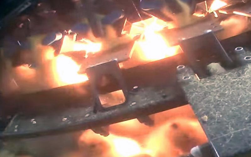 Close-up view of young ducklings under heat lamps in an industrial system.